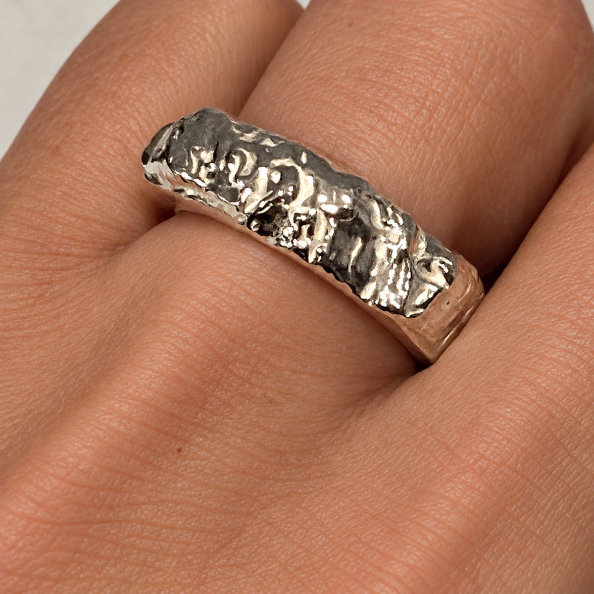 Anello Geo in argento 925 indossato, gioiello scultura ispirato alle forme della roccia e alle formazioni della terra, realizzato a cera persa in Italia.