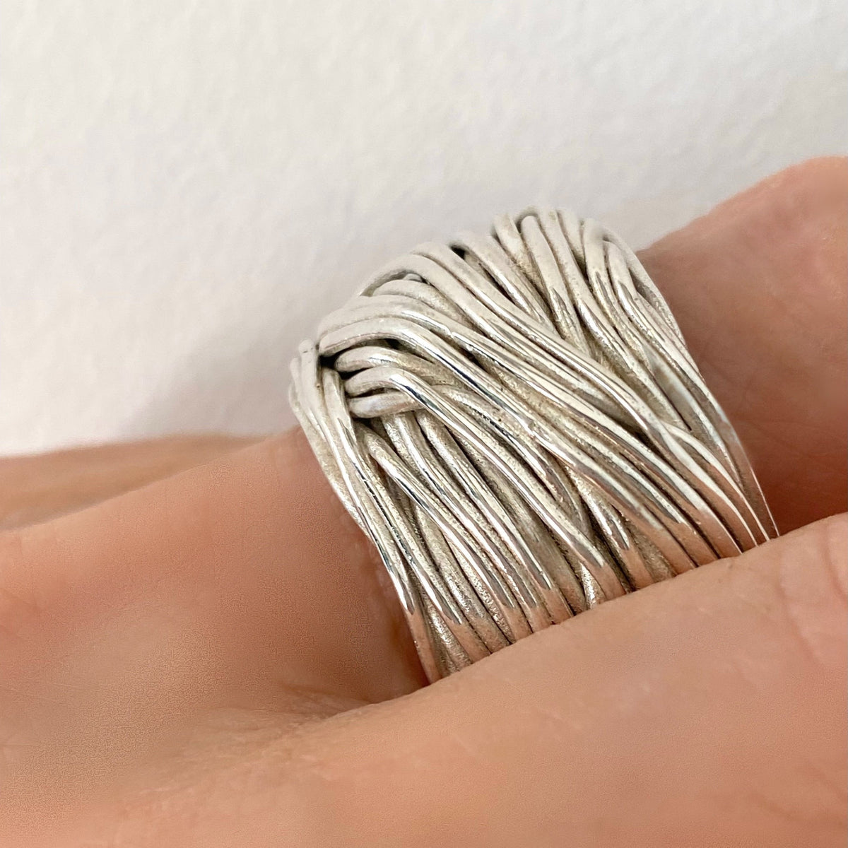 Anello Intrecci di Vita MilleFili Plus indossato, in argento 925 con molteplici fili intrecciati in una forma importante e bombata, L’Arte di Carlotta